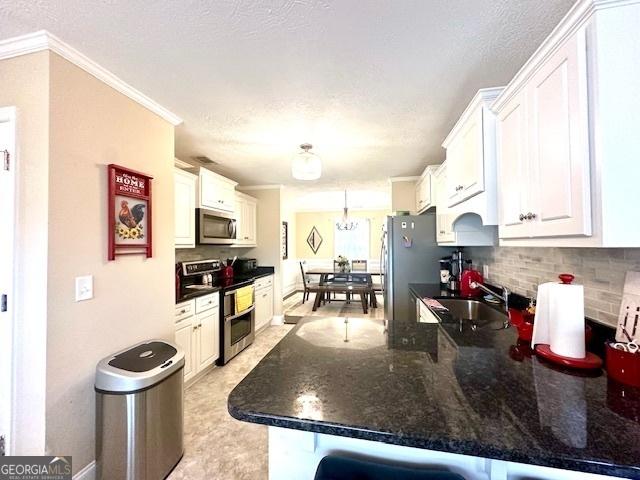 kitchen featuring white cabinets, a breakfast bar, stainless steel appliances, and kitchen peninsula