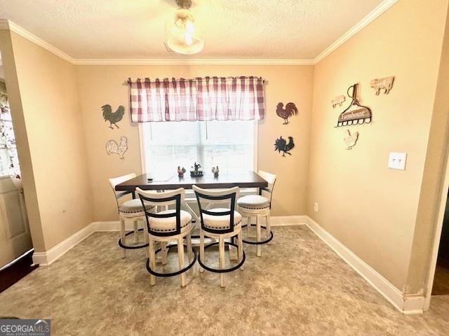 dining area featuring ornamental molding and a textured ceiling