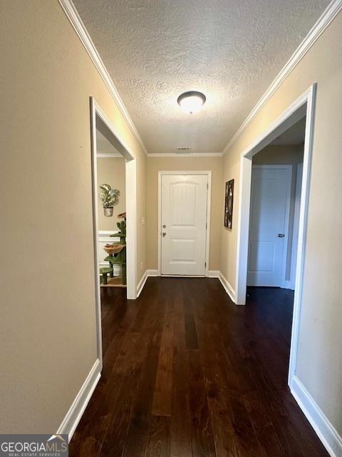 hall with dark hardwood / wood-style flooring, crown molding, and a textured ceiling