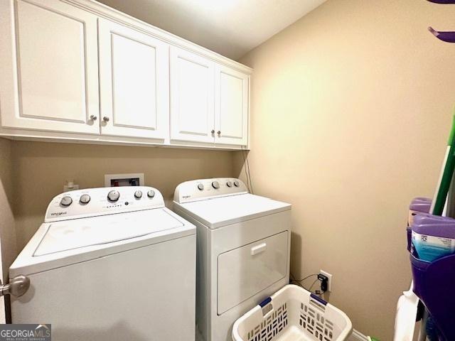 laundry room featuring cabinets and washer and dryer