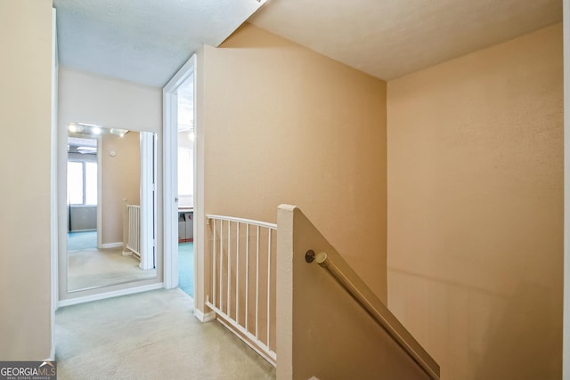 hallway featuring light colored carpet