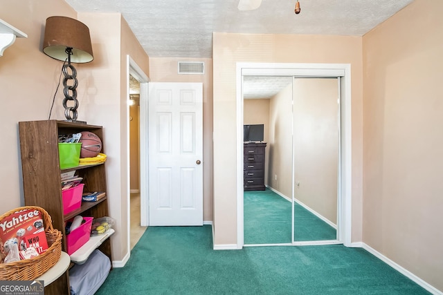 carpeted bedroom with a closet and a textured ceiling