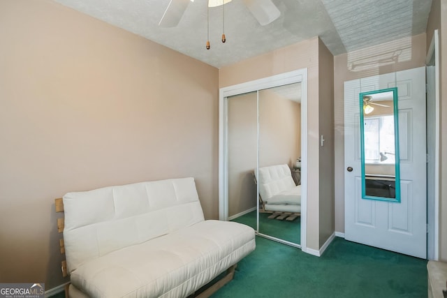 living area featuring ceiling fan and dark colored carpet