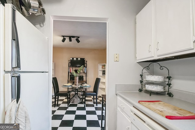 kitchen featuring track lighting, white refrigerator, and white cabinets