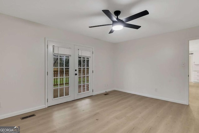 spare room with ceiling fan, light wood-type flooring, and french doors