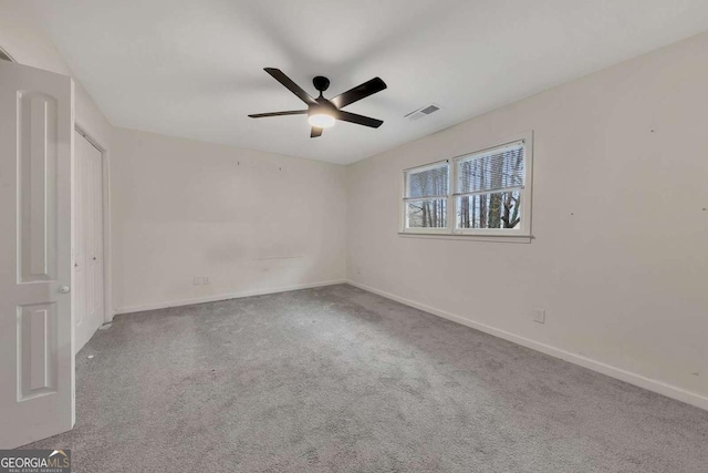 carpeted spare room with ceiling fan