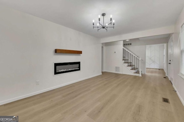 unfurnished living room with light wood-type flooring and a chandelier