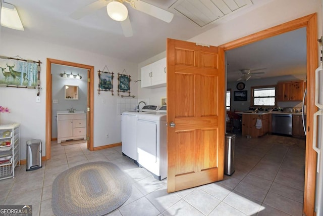 laundry room with washing machine and dryer, sink, light tile patterned floors, cabinets, and ceiling fan