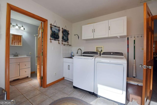 laundry area with sink, cabinets, washer and clothes dryer, and light tile patterned floors