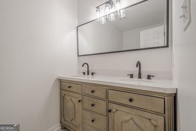 bathroom with double vanity, baseboards, and a sink