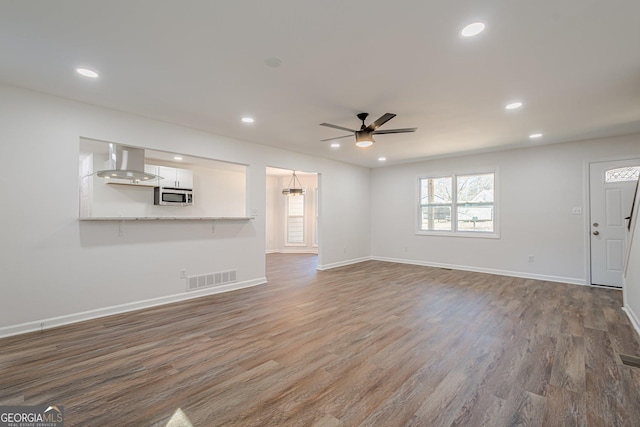 unfurnished living room featuring visible vents, recessed lighting, and wood finished floors