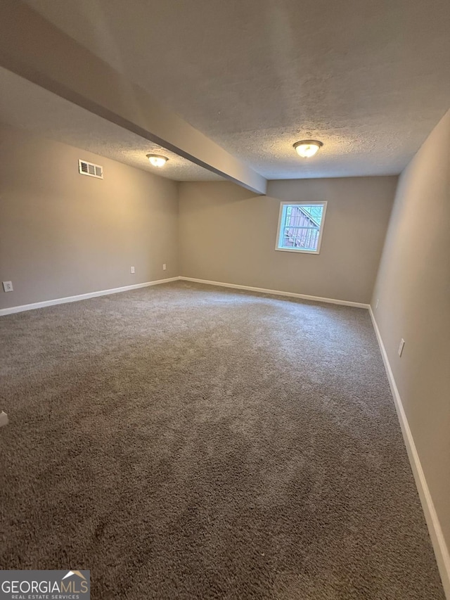 unfurnished room with a textured ceiling and carpet