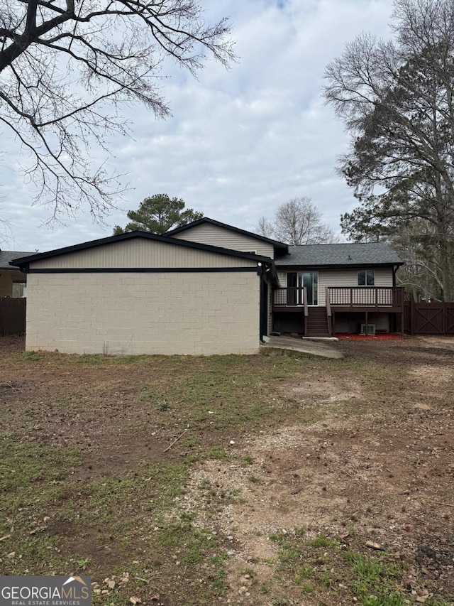 rear view of property with a lawn and a wooden deck