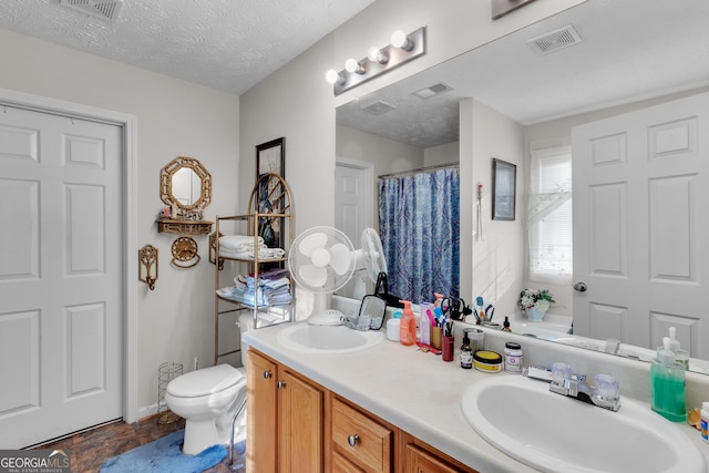 bathroom with visible vents, a sink, and a textured ceiling