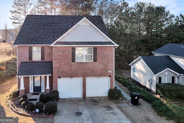 traditional-style house featuring a shingled roof, concrete driveway, and brick siding