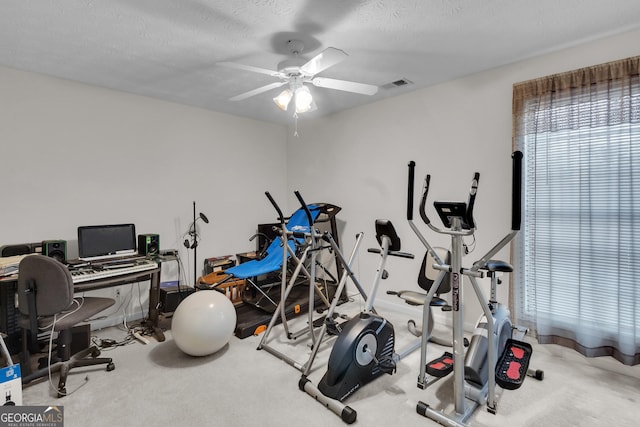 workout area with light carpet, ceiling fan, a textured ceiling, and visible vents