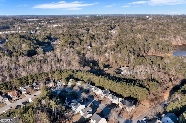 birds eye view of property featuring a forest view and a water view