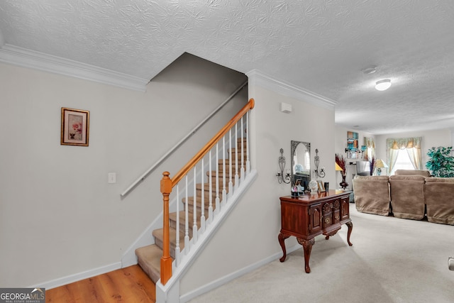 stairway featuring crown molding, a textured ceiling, and baseboards