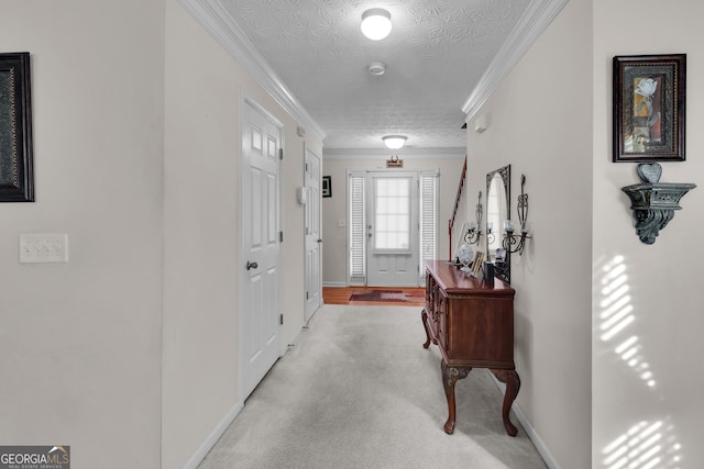 foyer entrance with ornamental molding, light carpet, a textured ceiling, and baseboards