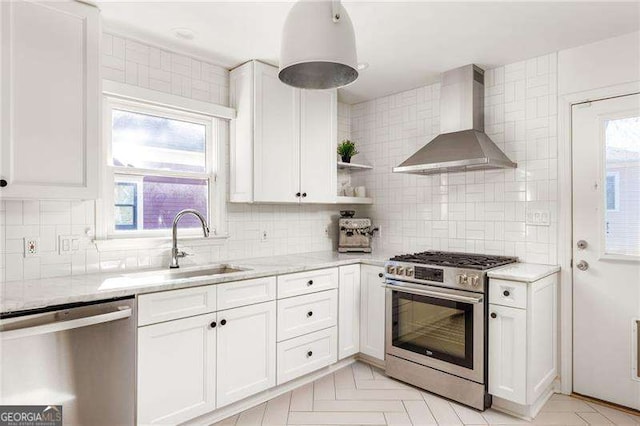 kitchen with appliances with stainless steel finishes, wall chimney exhaust hood, light stone counters, and white cabinets