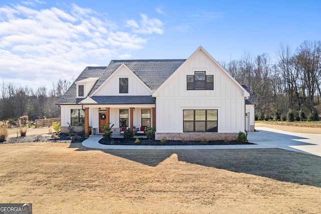 modern farmhouse style home featuring board and batten siding, roof with shingles, and covered porch