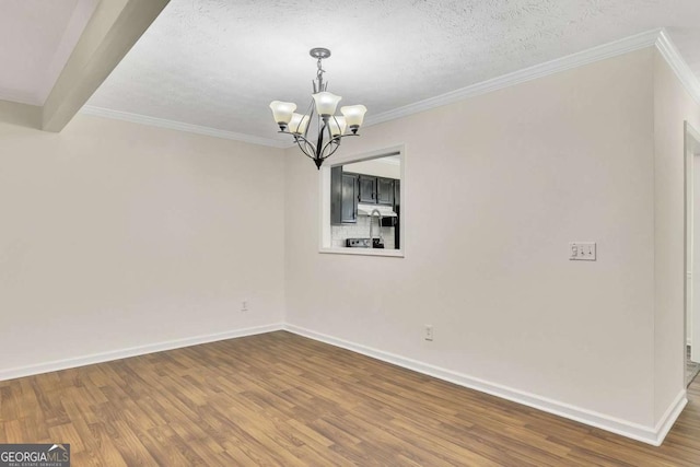 unfurnished dining area with a textured ceiling, crown molding, an inviting chandelier, and wood-type flooring