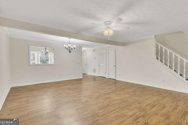 unfurnished living room with ceiling fan with notable chandelier, light wood-type flooring, crown molding, and a textured ceiling