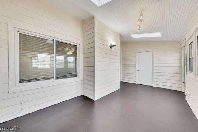 unfurnished sunroom featuring plenty of natural light and lofted ceiling with skylight