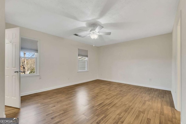 unfurnished room with ceiling fan, light hardwood / wood-style flooring, and a textured ceiling
