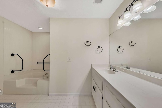 bathroom featuring a bathing tub, vanity, and tile patterned floors