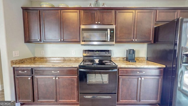 kitchen with black appliances and light stone counters