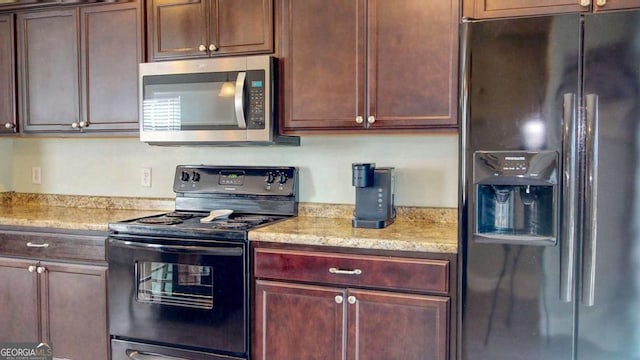 kitchen with black appliances and light stone countertops