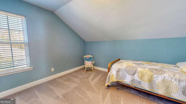 bedroom featuring carpet flooring, vaulted ceiling, and multiple windows