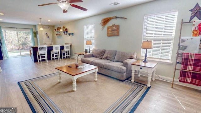 living room with ceiling fan and light hardwood / wood-style flooring