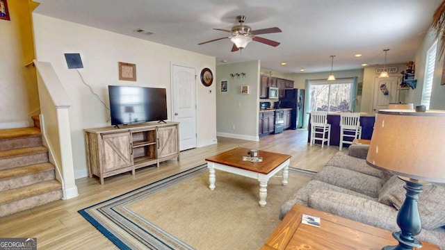 living room featuring light hardwood / wood-style floors and ceiling fan