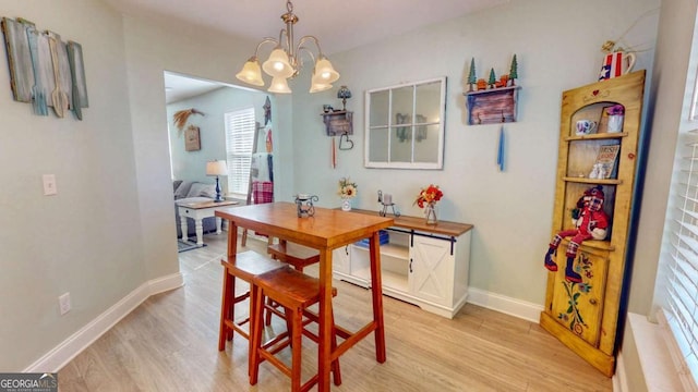 dining space with a notable chandelier and light wood-type flooring