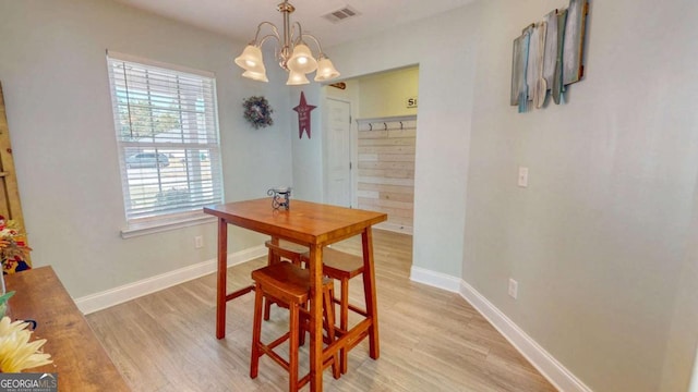 dining space with a chandelier and light hardwood / wood-style floors