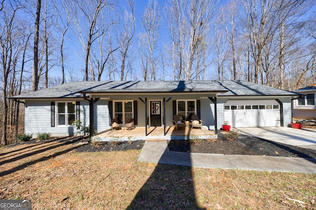 ranch-style house featuring a garage, covered porch, and driveway