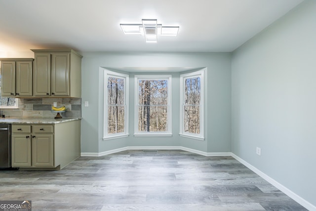 unfurnished dining area with light wood-style flooring and baseboards