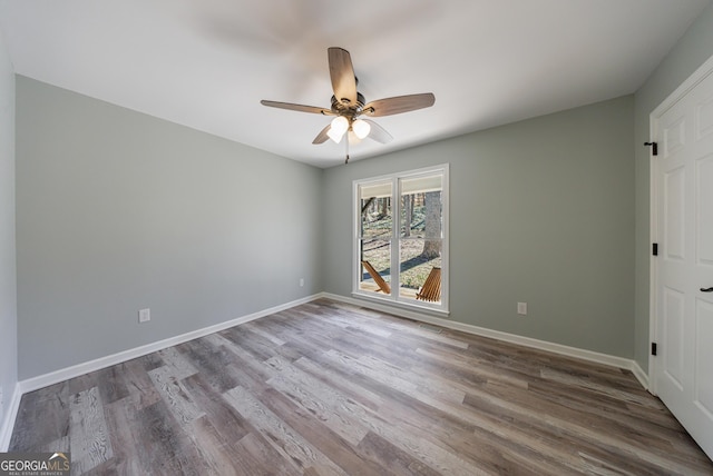 unfurnished bedroom with wood finished floors, a ceiling fan, and baseboards