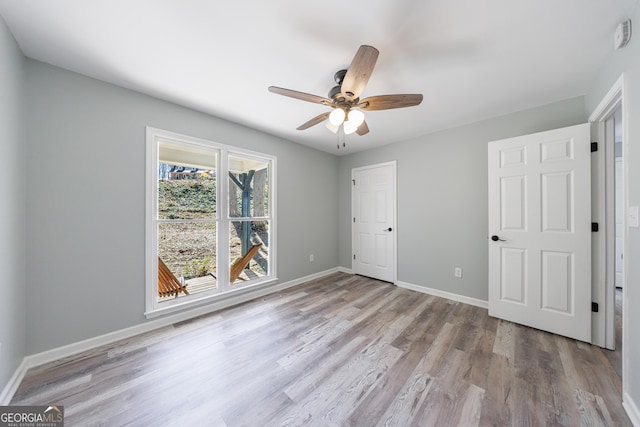 unfurnished bedroom with wood finished floors, a ceiling fan, and baseboards