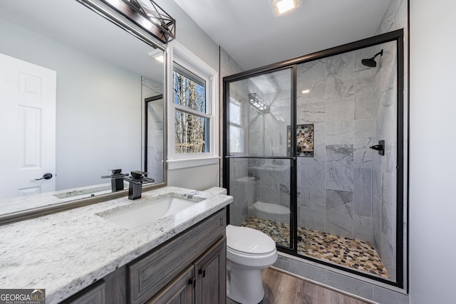 full bathroom with vanity, a stall shower, wood finished floors, and toilet