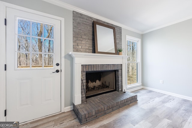 unfurnished living room with ornamental molding, a fireplace, wood finished floors, and baseboards