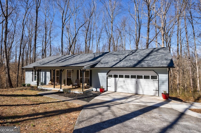 ranch-style house with covered porch, driveway, roof with shingles, and an attached garage