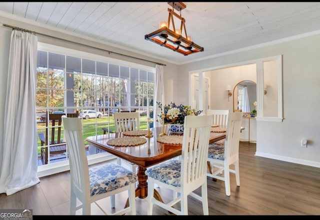 dining room with ornamental molding, dark hardwood / wood-style floors, and wood ceiling