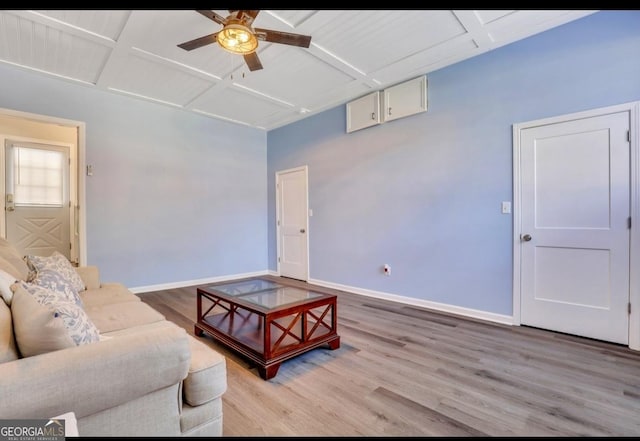 living room with light wood-type flooring, coffered ceiling, and ceiling fan