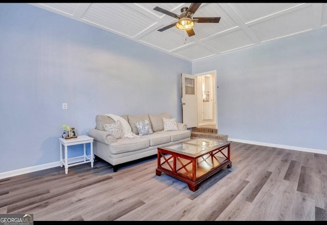 living room with ceiling fan, light hardwood / wood-style floors, coffered ceiling, and beamed ceiling