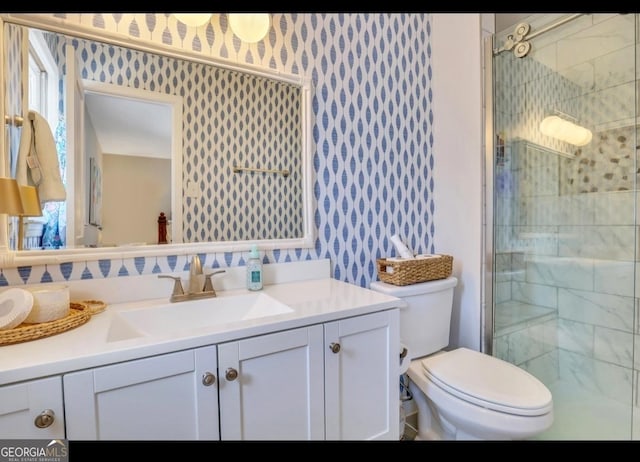 bathroom with vanity, toilet, and a shower with door