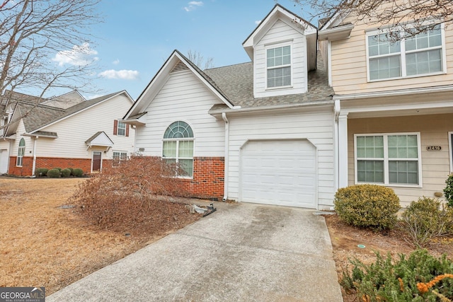 2414 Clock Face Ct, Lawrenceville, GA 30043 - view of front facade featuring roof with shingles, brick siding, driveway, and an attached garage