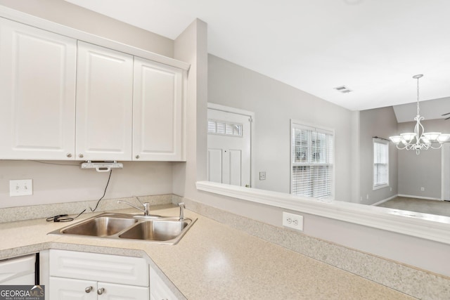 2414 Clock Face Ct, Lawrenceville, GA 30043 - kitchen featuring light countertops, a chandelier, and white cabinets